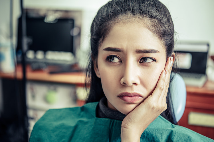 That woman had a toothache and a hand touch her cheek | Emergency Dental Visit
