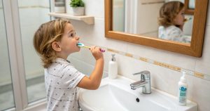 a photo of a kid in a bathroom setting showing how to make kids excited about brushing their teeth