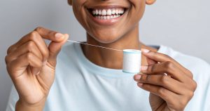 a person holding dental floss practicing the right flossing techniques