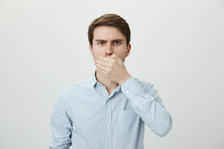 a photo of a man holding mouth because of bad breath 
