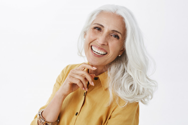 a woman smiling relieved from denture sores 