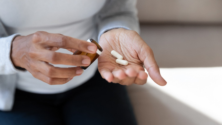 a photo showing a person taking antibiotics after tooth extraction