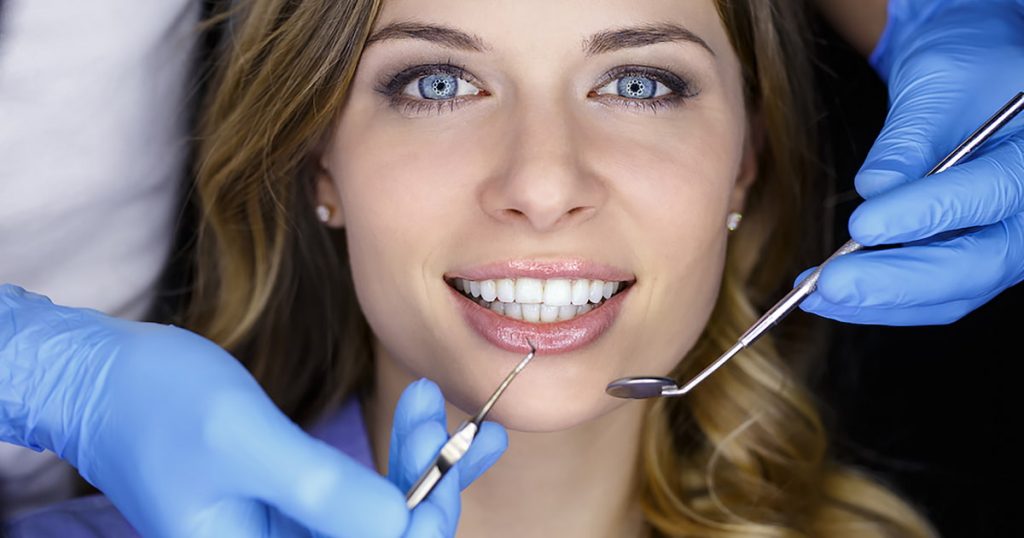 a photo of a lady with dental veneers in a dental clinic checking for any complications of veneers