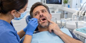 Dentist examining a tooth after a dental filling has fallen out.