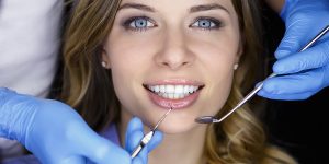 a photo of a lady with dental veneers in a dental clinic checking for any complications of veneers